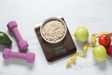 Electronic kitchen scale, measuring tape, dumbbells and products on white marble table, flat lay. Diet