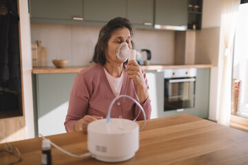 Senior woman using a nebulizer mask to manage breathing