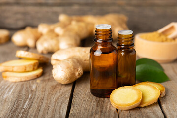 Ginger essential oil on texture background. Fresh ginger slices. Essence, serum, oil. Alternative...