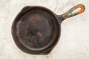 a small grunge, iron frying pan on a ceramic itled