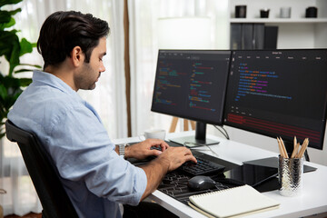 Smart IT developer working software development coding with creating application program update version online website on data's company system two computer code pc screen at modern office. Surmise.