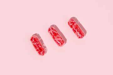 Medical pill capsules filled with colorful sugar sprinkles, creative concept