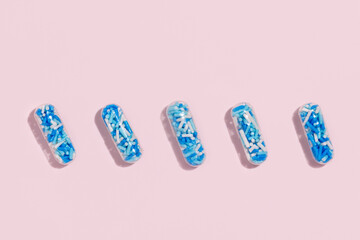 Medical pill capsules filled with colorful sugar sprinkles, creative concept