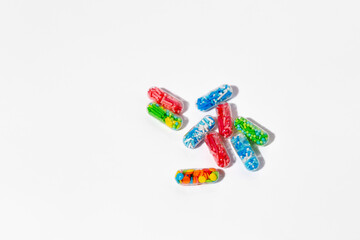 Medical pill capsules filled with colorful sugar sprinkles, creative concept