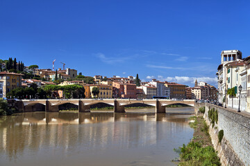 Obraz premium Bridge, tenement houses and historic buildings over the Arno river in the city of Florence