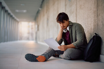 Young student feeling dissatisfied with his test results at university.