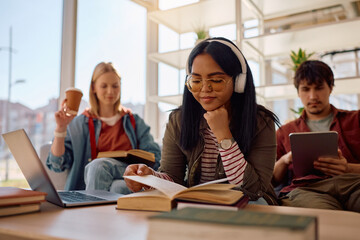 Smiling Indian student and her friends studying at university.