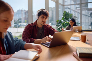 Young student using laptop while learning at university.