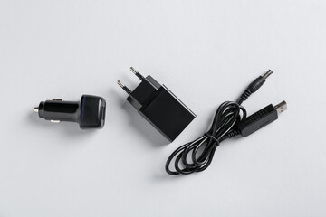 USB power adapter, charge cable and car charger on white background, flat lay