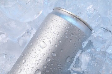 Refreshing drink in can on ice cubes, closeup