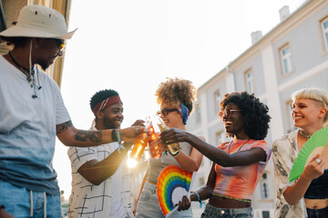 Friends toasting with beer bottles at pride parade celebrating lgbtq plus rights