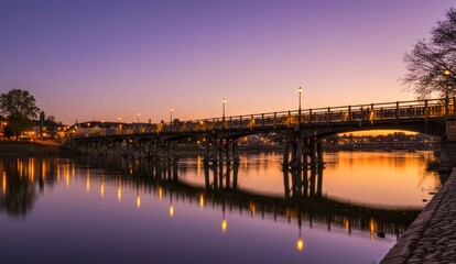 Bridge over a river at dusk, with reflections in the water,