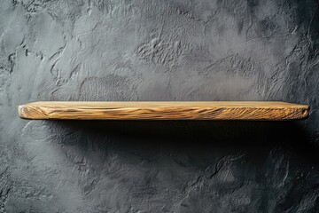 Empty wooden shelf against dark textured wall
