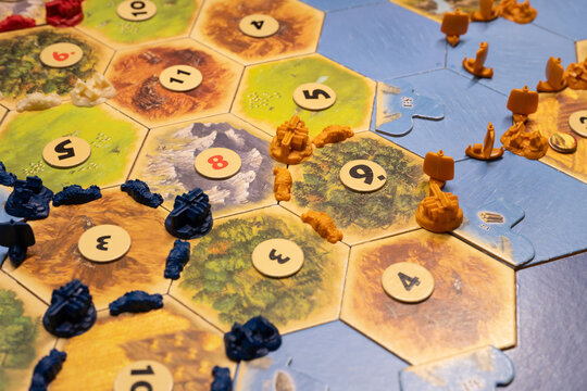Turkey, Istanbul - 4 March 2025: Catan board game. Hexagonal tiles board game with settlements and ships placed on a table, ready to be played