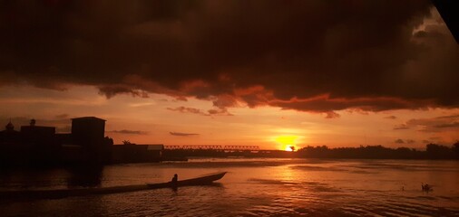 Fototapeta premium Scenic Dusk View with Silhouetted Boat on Wide River
