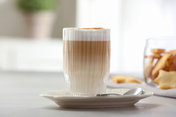 Tasty latte macchiato in glass on white table, closeup. Coffee drink