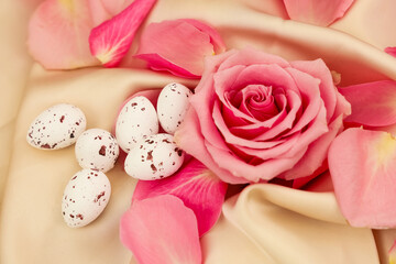 Speckled eggs lie among soft pink rose petals, capturing the essence of springtime decor.