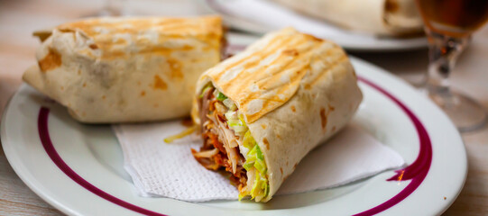 Fresh tasty turkish wrapped dish durum cutted on halves on white plate