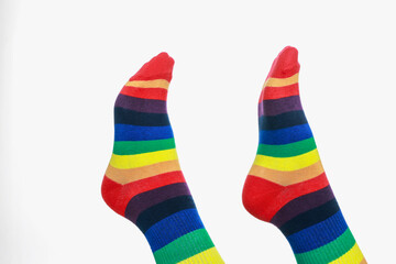 Woman wearing socks in LGBT colors on white background, closeup