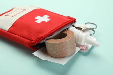 First aid kit. Different medical supplies on light blue background, closeup