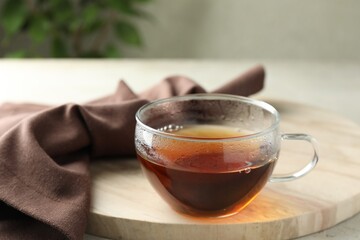 Aromatic tea in cup on light table, closeup