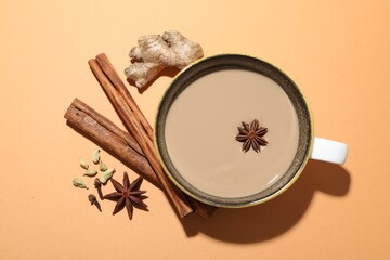Aromatic Masala tea in cup and spices on beige background, flat lay