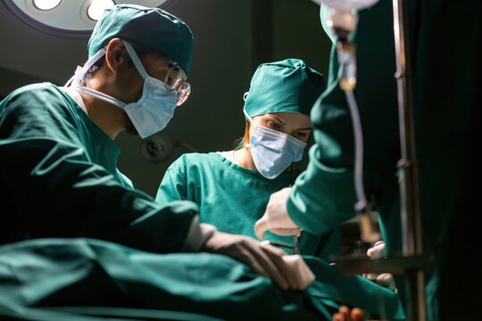 emergency doctor group working using tools to save people. specialist surgical team performing medical tools procedure. medical staff team wearing uniform helping patient in surgery with equipment