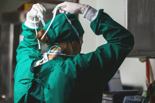 female caucasian doctor operating preparing hat. specialist surgical woman tighten wearing medical cap before doing surgery. female surgeon wearing uniform putting hair net working in emergency room