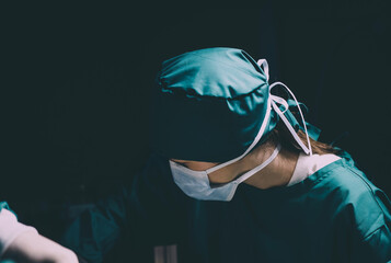 female caucasian doctor operating emergency room. specialist surgical woman determined doing surgery to help patient in operating room. female surgeon wearing uniform working in emergency operation