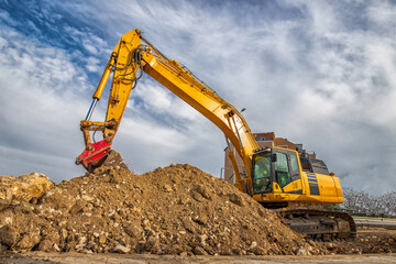 Obraz premium A stopping yellow excavator, at a construction site