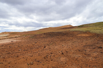 Geothermal area creating colorful slopes in Iceland under cloudy sky