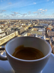Cup of coffee with panoramic view of Warsaw, Poland, from a high-rise window. Urban skyline, clear skies and modern architecture create a perfect blend of relaxation and city vibes