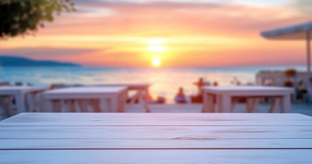 Une table en bois blanc avec un arrière-plan flou représentant un restaurant en plein air et une vue sur la mer au coucher du soleil, concept de présentation de produits ou une publicité.
