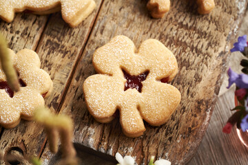 Four-leaf clover shaped Linzer Easter cookie filled with marmalade and dusted with sugar