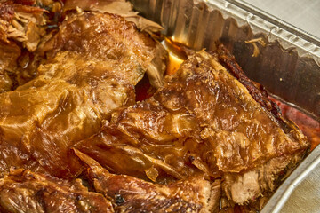 Juicy roasted suckling pig with crispy skin in metal tray