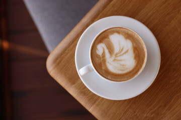 Cup of aromatic coffee on wooden table in cafe, top view. Space for text