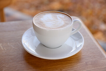 Cup of aromatic coffee on wooden table in cafe, closeup