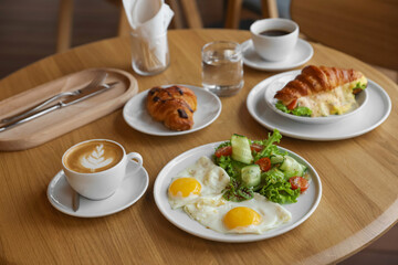 Delicious breakfast served on wooden table in cafe