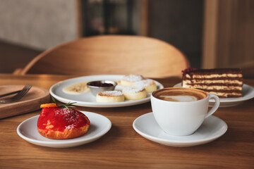 Aromatic coffee and delicious desserts served on wooden table in cafe