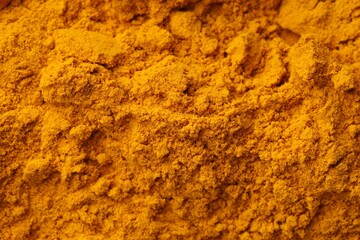 Aromatic turmeric powder as background, top view