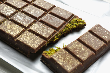 Delicious Dubai chocolate with pistachios and knafeh on table, closeup