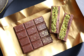 Pieces of delicious Dubai chocolate with pistachios and knafeh on table, top view