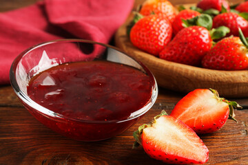 Delicious strawberry sauce and fresh berries on wooden table, closeup