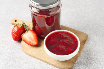 Delicious strawberry sauce and fresh berries on light table, closeup