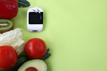 Glucometer and fresh vegetables on a bright background