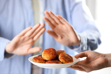 Woman refusing patties indoors, selective focus. Food allergy concept