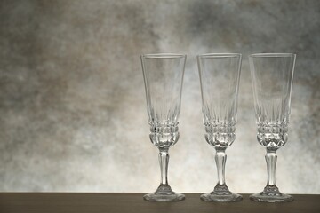 Three empty clean glasses on wooden table. Space for text