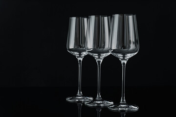 Three empty clean glasses on black background