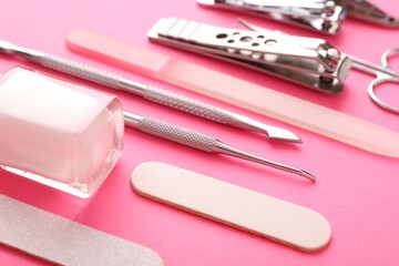 Set of different manicure tools on bright pink background, closeup