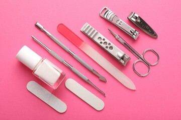 Set of different manicure tools on bright pink background, flat lay